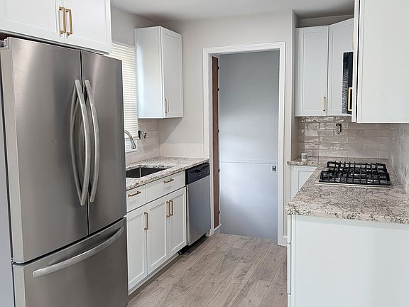 Kitchen with large fridge and lots of natural daylight from large windows