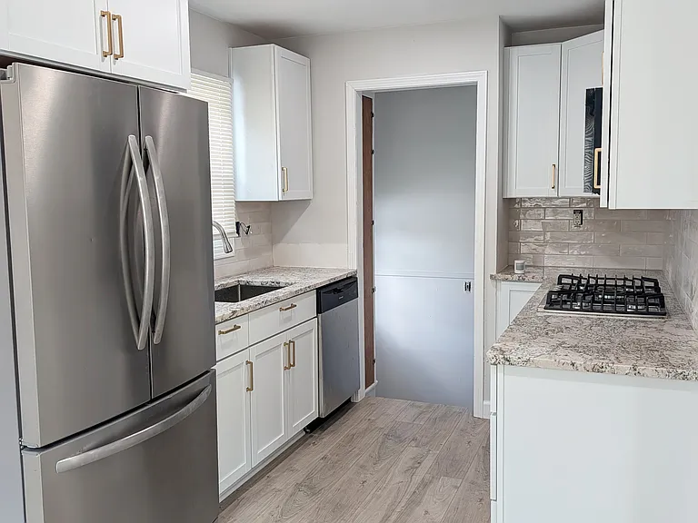 Kitchen with large fridge and lots of natural daylight from large windows