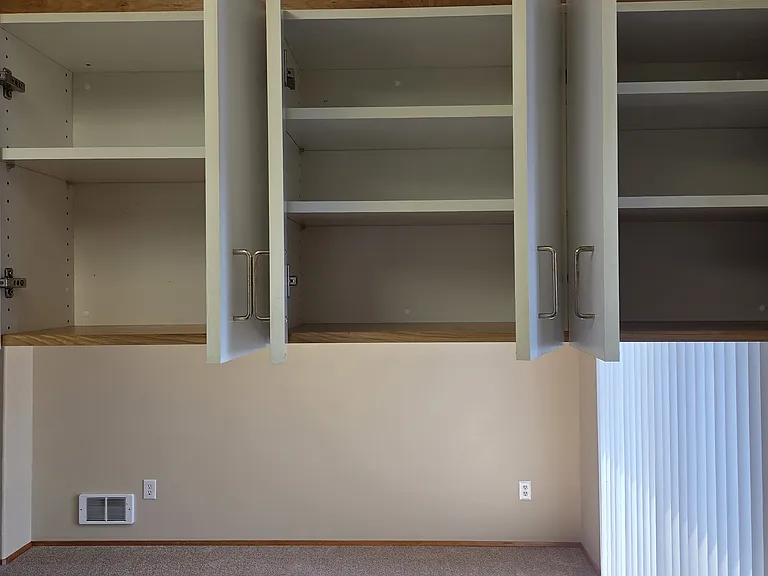 View of additional cabinet shelves and dining room.
