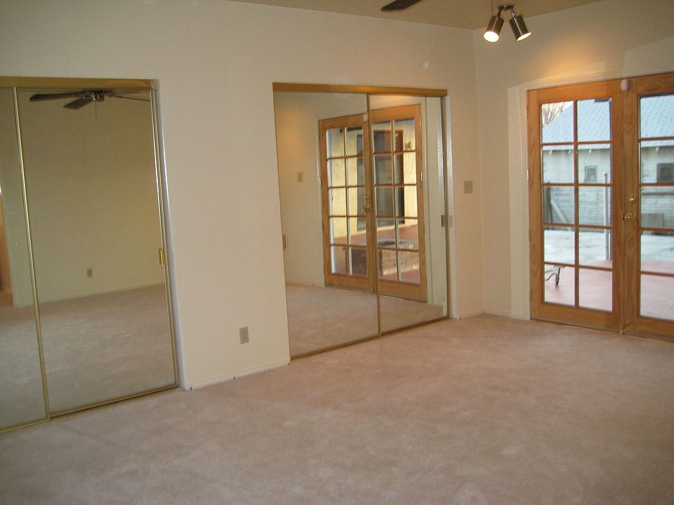 Master bedroom with mirrored closet doors and french doors to covered patio