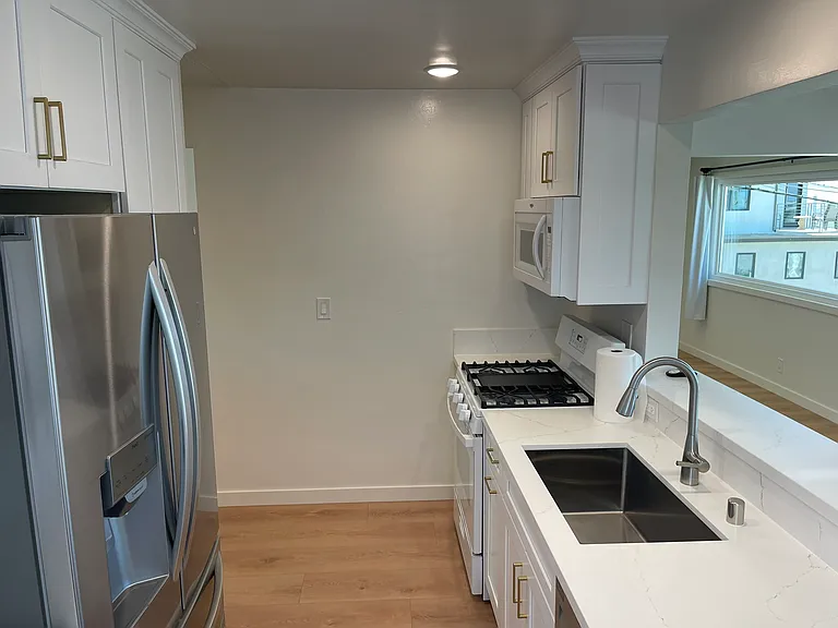 Quartz countertops with ribbons of gold. Full basin sink. Over-the-stove space-saving microwave.