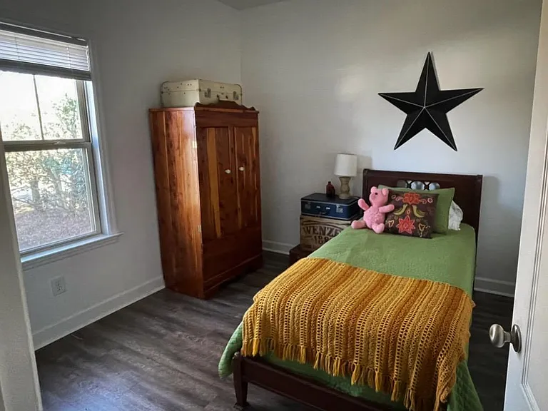 Front room with twin bed and wardrobe. Additional storage in a standard closet located to the left of this frame.