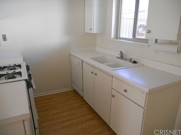 Fresh sparkling kitchen looks out to covered patio.