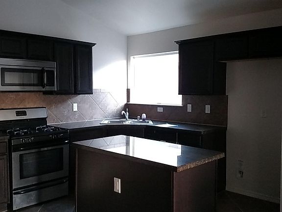 Kitchen Island with dining area to the left. Refridgerator