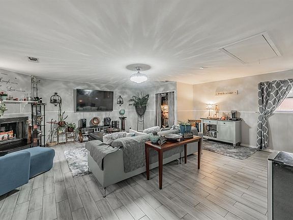 Living room with attic access, tiled floors, and a fireplace