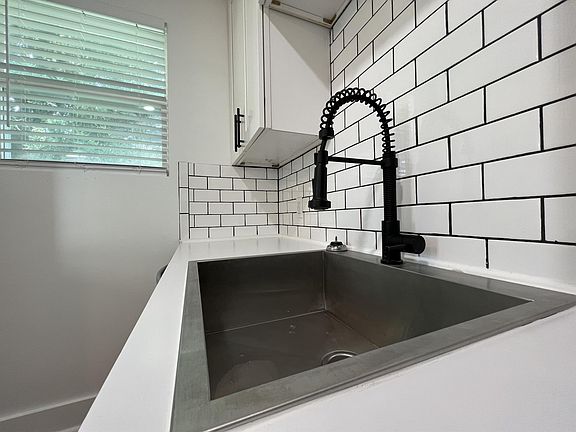 Kitchen has a deep, stainless steel sink with a telescoping faucet.