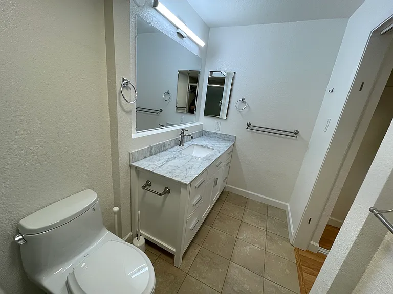 Master bathroom with marble vanity and walk-in shower located next to double-closets in master bedroom. This bathroom has an accordion door for extra privacy.