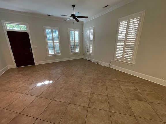 The living room shows plenty of windows and a transom window over the front door for lots of direct and indirect passive light