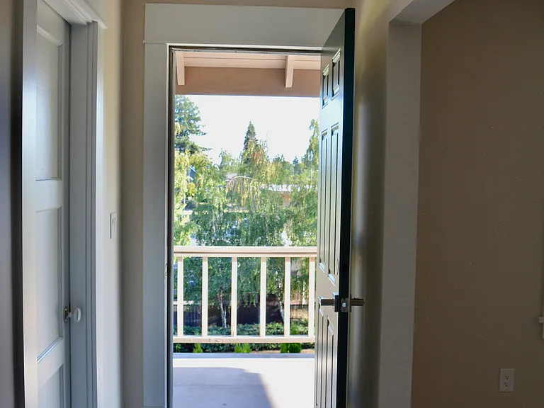 Door to the deck from the living room. The door to the left is the master bedroom with a walk-in closet