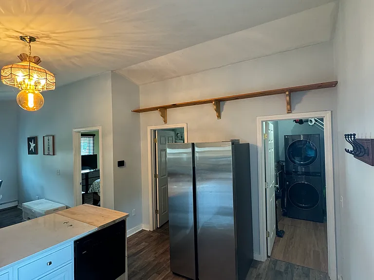 Refrigerator and view of kitchen.