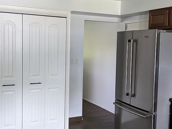 Double-door pantry is close to refrigerator.