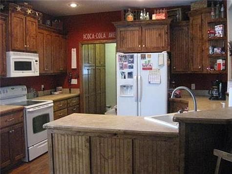 Kitchen opens to laundry room with custom knotty alder pantry.