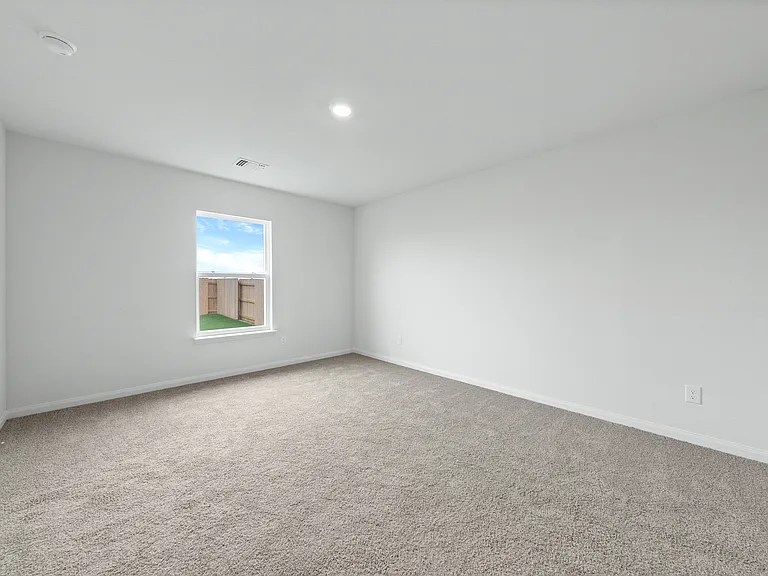 The master bedroom of the Sabine is spacious and has a large window.