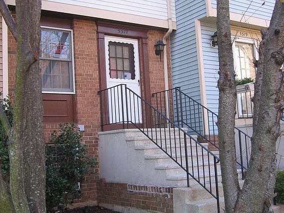 Front of townhouse has a tree in front for shade in the summer