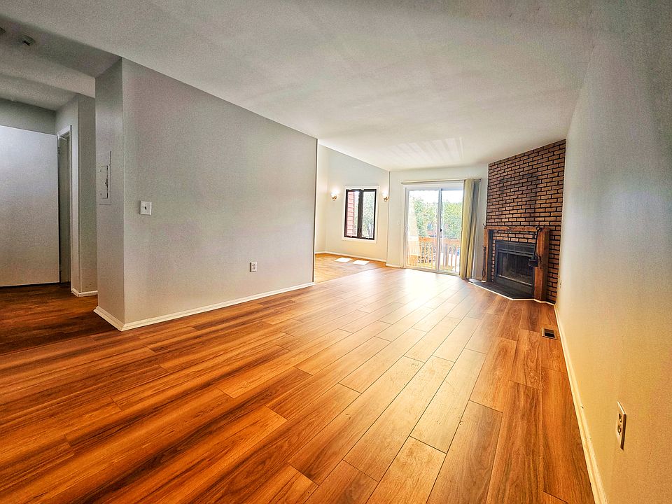 Spacious living room with a cozy fireplace, connected to the dining room.