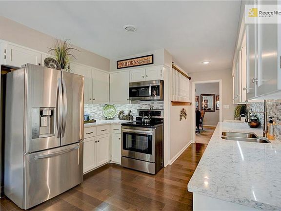 Updated kitchen w/ white cabinets and SS appliances.