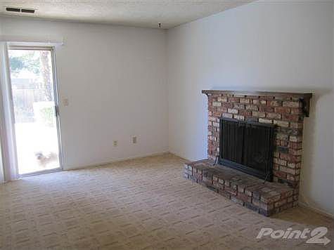 Living room with brick fireplace and berber carpeting.