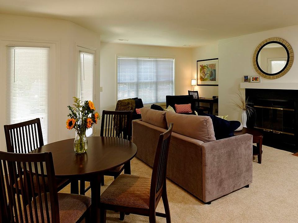 Carpeted dining and living area with fireplace