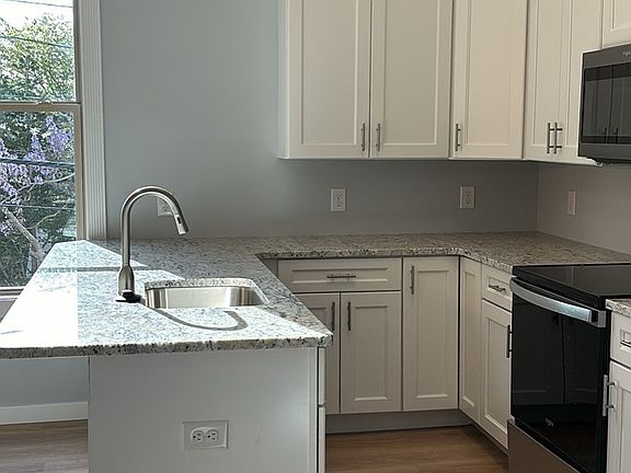 Kitchen has full stainless steel Whirlpool appliance package and granite counter tops with pendant lighting.