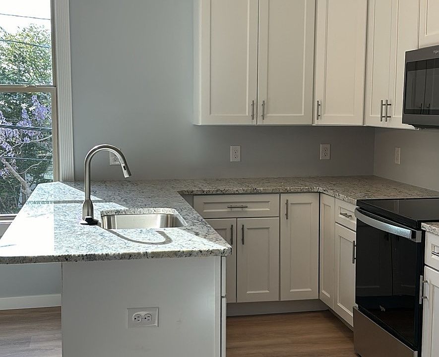 Kitchen has full stainless steel Whirlpool appliance package and granite counter tops with pendant lighting.