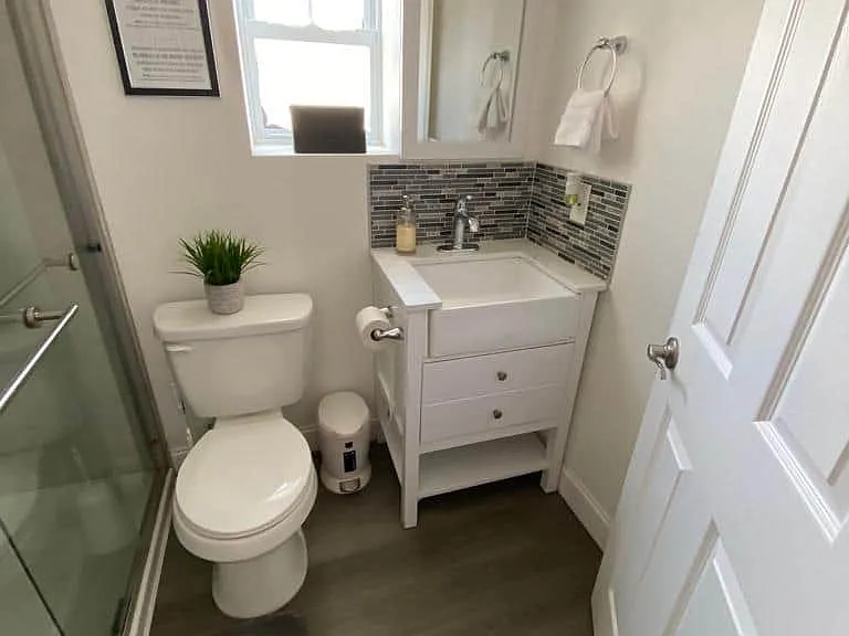 Bright bathroom featuring a window, cozy decor, towels, and towel holders.