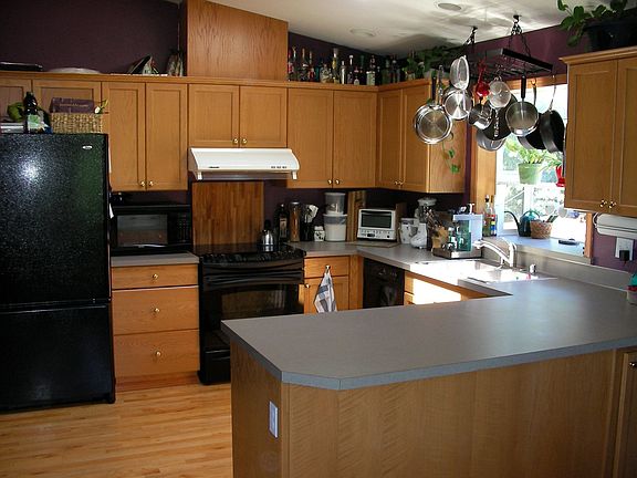 Kitchen, viewed from dining area, opening to great room at left.