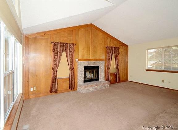 Main level living room with wood burning fireplace - view from e