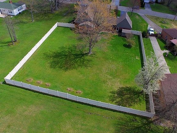 Large back yard with new vinyl fencing, concrete patio and storage shed.