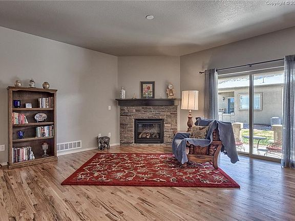 The great room has wood flooring and the 1st of two gas fireplaces with a blower