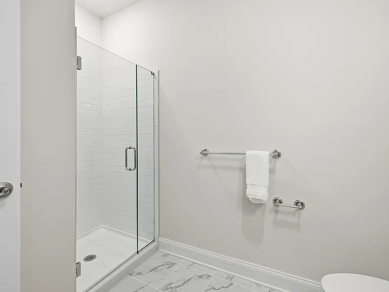 Spacious full bathroom in the 4th Bedroom ensuite features quartz vanity and subway-tiled stall shower.