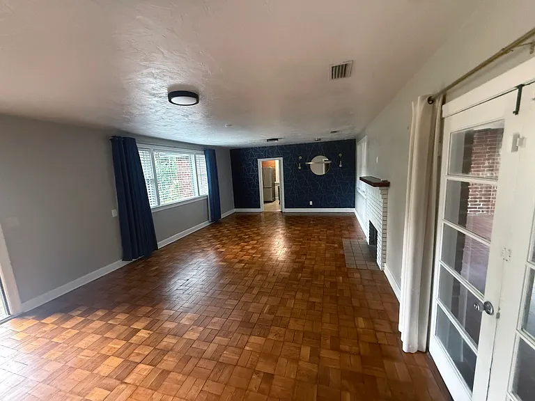 Living room with fireplace; far door is to kitchen, close door is to Florida room. Blackout drapes.