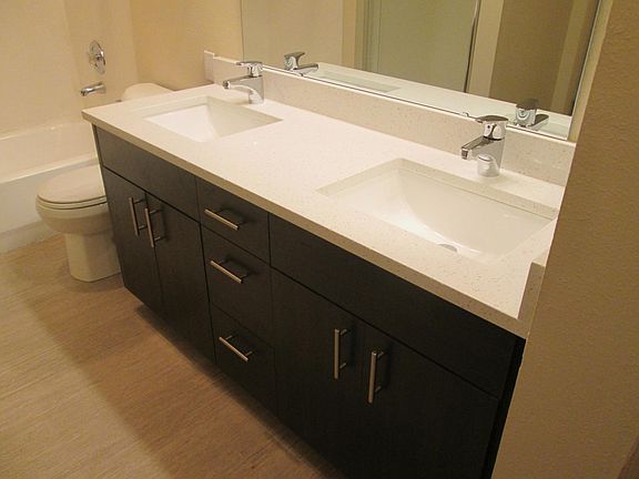 Newly renovated bathroom with dual vanity, stand up shower, tub/shower and stacked washer/dryer.
