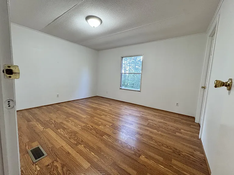 Large third bedroom with beautiful hardwood floors, a walk-in closet, and plenty of space for home office, or guest room. Bright window overlooks the side and backyard, bringing in natural light throughout the day.