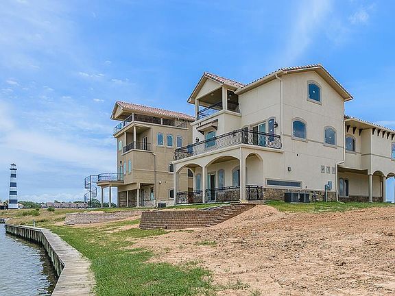 TWO OF THE NEIGHBORING CUSTOM LAKEFRONT HOMES IN BEACON ISLAND.