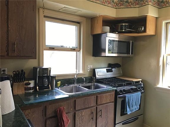 The kitchen has a double sink under the window and has a door to a small deck. All appliances will remain. There is a ceiling fa
