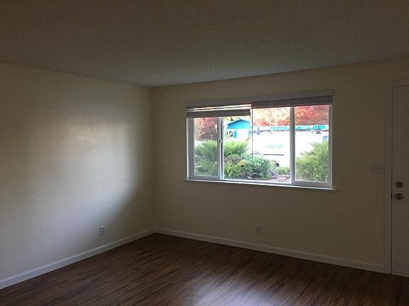 Living room with new laminate flooring and freshly painted walls, ceiling and trim.