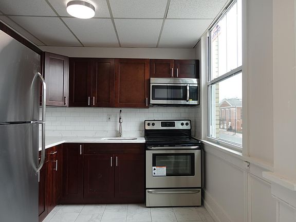 Renovated kitchen with stainless steel appliances, subway tile back drop, new tiles, new cabinets, convenient drop down sink sprayer faucet. microwave