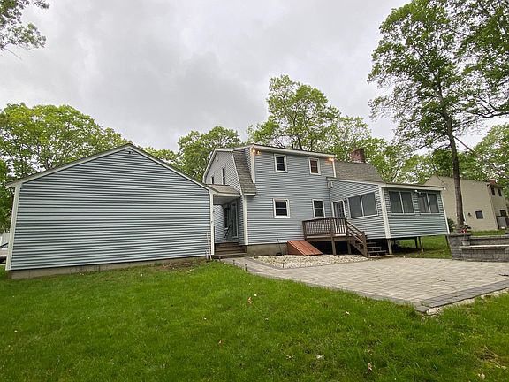 Rear of garage and house with deck and patio area.