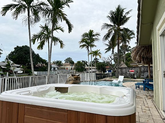 Back patio with hot tub, pool and dock