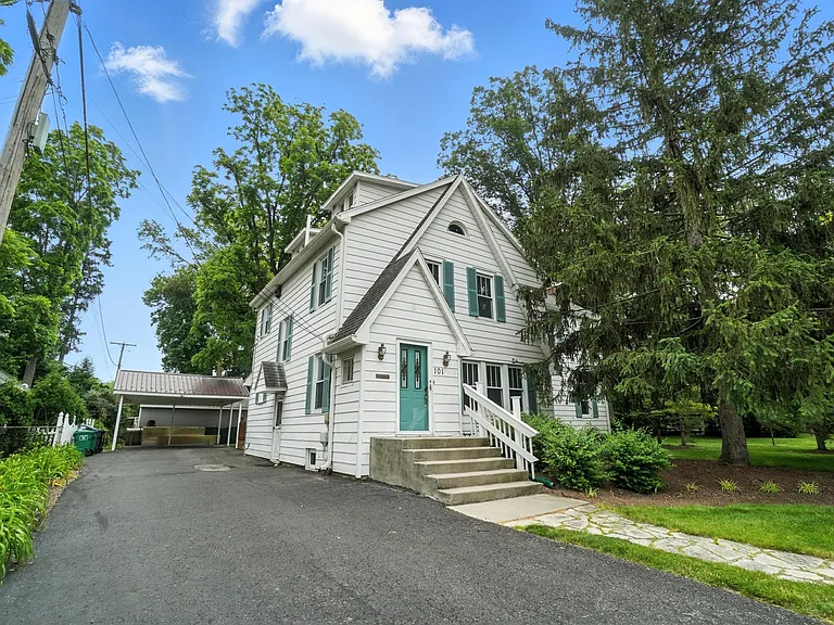 Asphalt drive leading to the carport at the rear of the property. The side roof indicates a side entrance door. There are also two rear doors, one patio leading into the kitchen off the deck and an entrance door into the sunroom.