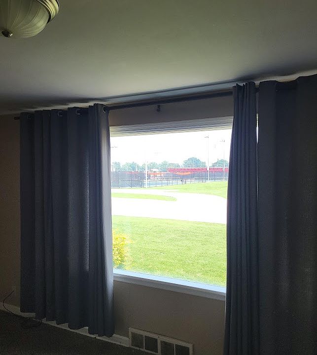 Picture window with view of athletic field, tennis courts across the street.