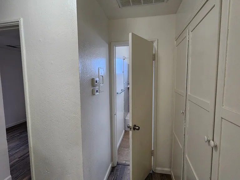 Hallway to bathroom with extra storage.