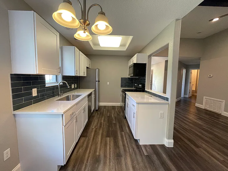 Beautifully remodeled chef's kitchen with quartz counter tops, stainless steel appliances and shaker cabinets