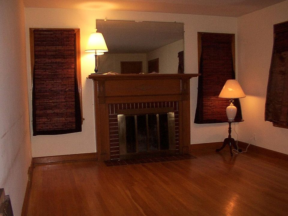 living room with fireplace, hardwood floors, microfiber suede furniture, desk, Roman blinds, entertainment center with TV