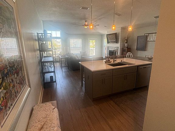 Hallway looking into kitchen, living room and front balcony
