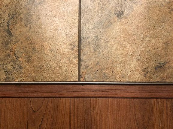 Tile and laminate floor. Laminate floor in living, dining area. Tile in laundry, entry, kitchen and bathrooms. Carpet in bedrooms.