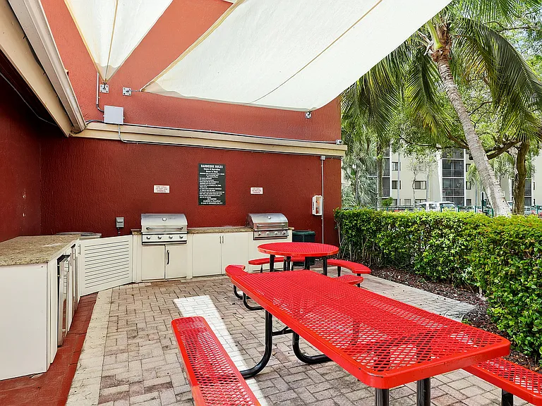 Inviting outdoor barbecue area with vibrant red picnic tables