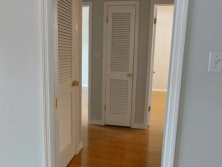Hallway to bedrooms with additional storage closets. Option to separate the living space from the bedrooms with a pocket door.