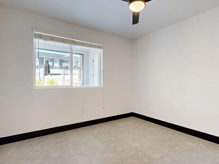 Spacious apartment bedroom with tile floor.