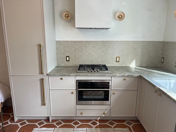 Kitchen with Burner, Convection Microwave, Refrigerator, Sink and Dishwasher. Premium unlaquered brass finishes.